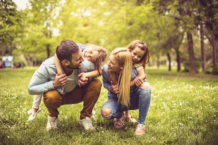 Happy young smiling family playing at park.