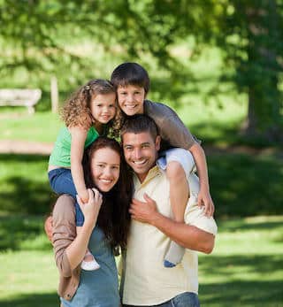 Keeping your family smiling and in good health Two parent with a child on their shoulders