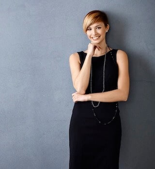 Beautify your smile at Boise Dentistry Co. Beautiful young woman in black dress touching her chin