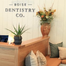 Boise Dentistry Co. Reception area new patients with their logo on a wooden wall