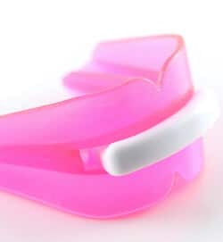 A pink mouthguard fitting during a family dentistry visit